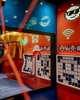 Close-up of an interactive module combining screens, pictograms, and colorful illustrations to raise awareness about digital communication and online safety.