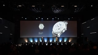 Product presentation on stage featuring a luxury watch displayed on a large screen during Watches & Wonders – Geneva International Watchmaking Exhibition.