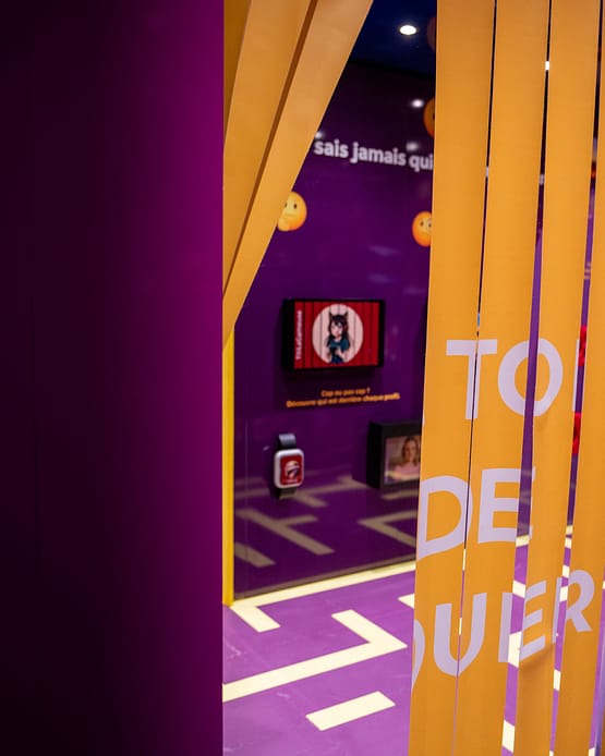 Partial view of a scenographed corridor where color palettes, typography, and spatial design guide visitors through the different educational modules of the pavilion.